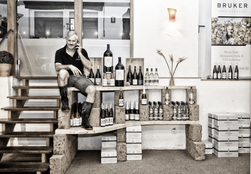 自らのワインとともに写る醸造家マルクス・ブルカー